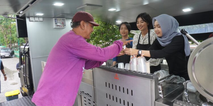 FOTO: MATAKALTENG - Personel Ditsamapta Polda Kalteng, pada saat menyalurkan makanan kepada warga Kota Palangka Raya.