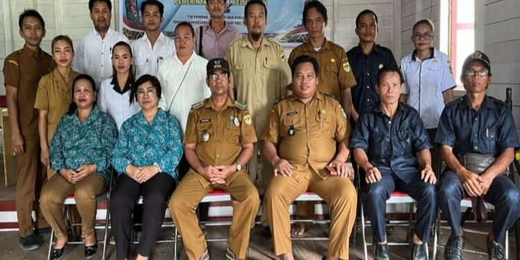 FOTO: SUDIRMAN/MATA KALTENG - Camat Damang Batu Sudirman (tiga dari kiri), berfoto bersama dengan kades dan perangkat Desa Tumbang Maraya, belum lama ini.