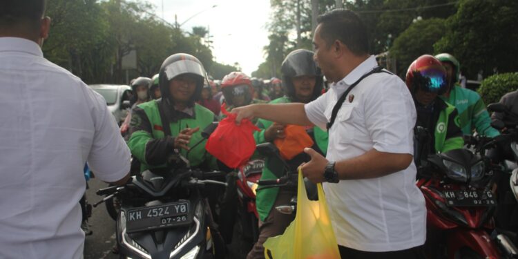 FOTO: MATAKALTENG - Jajaran Ditreskrimsus Polda Kalteng pada saat membagikan takjil kepada pengendara di Jalan Yos Sudarso.