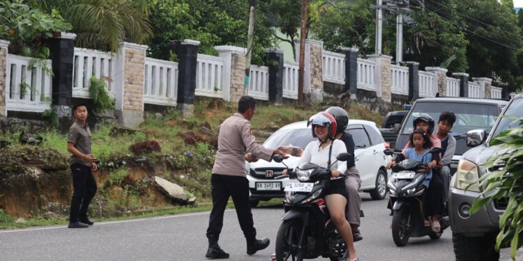 FOTO : HUMAS POLRES GUMAS/MATA KALTENG - Kapolres Gumas AKBP Theodorus Priyo Santosa bersama puluhan personel polres ketika membagikan takjil berbuka puasa kepada pengendara yang melintas, Selasa, 4 Maret 2025 sore.