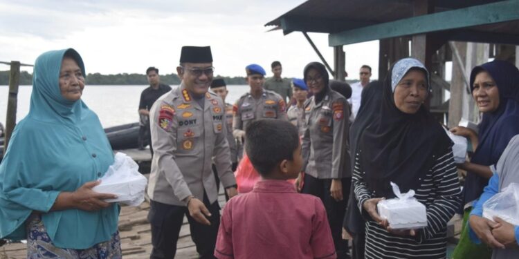 FOTO: IST/MATAKALTENG- Terlihat Dirpolairud Kombes Pol. Dony Eka Putra saat membagikan takjil kepada masyarakat di sekitar sungai mentaya Sampit.
