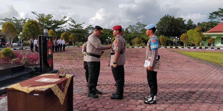 FOTO : HUMAS POLRES GUMAS/MATA KALTENG - Kapolres Gumas AKBP Theodorus Priyo Santosa saat menyematkan tanda pangkat kepada kasat reskrim dalam acara sertijab, di halaman mapolres setempat, Jumat, 7 Maret 2025.