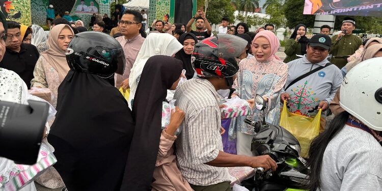 FOTO: IST/MATAKALTENG - Ketua TP PKK Kalteng, Aisyah Thisia Agustiar Sabran membagikan 1000 takjil kepada warga yang melintas di Kawasan Bundaran Besar Istana Isen Mulang, Rumah Jabatan Gubernur.