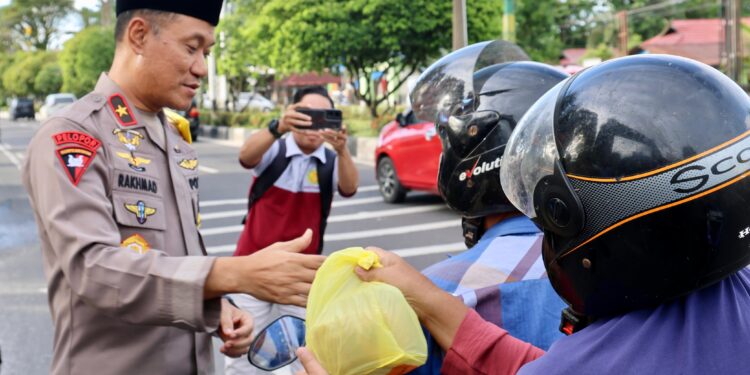 FOTO: MATAKALTENG - Wakapolda Kalteng, Brigjen Pol Rakhmad Setyadi, pada saat membagikan takjil kepada pengendara yang melintas di depan Mapolda Kalteng.