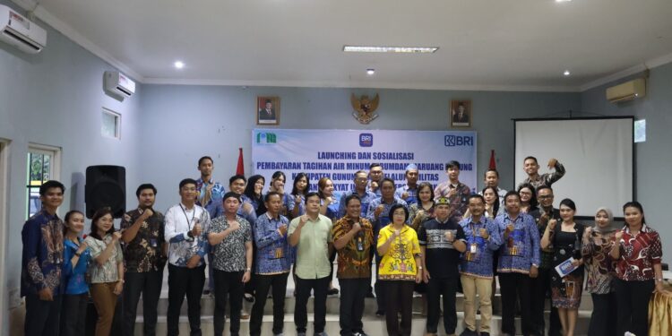 FOTO : DISKOMINFO SANTIK/MATA KALTENG - Wakil Bupati Gumas Efrensia LP Umbing didampingi Direktur Perumdam Maruang Duhung Hendra Toendan serta Kepala Capem BRI Kuala Kurun Utas Wenly, berfoto bersama dengan pegawai perumdam, karyawan BRI dan pelaku usaha, pada kegiatan launching pembayaran rekening air bersih dengan sistem online, Selasa, 18 Maret 2025 sore.