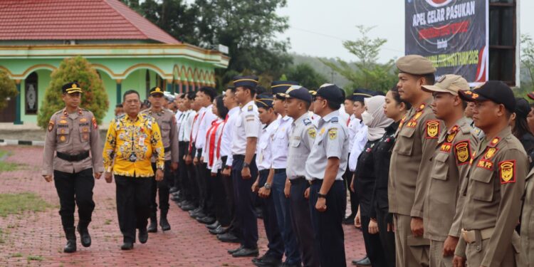 FOTO : HUMAS POLRES GUMAS/MATA KALTENG - Wakapolres Gumas Kompol Indras Purwoko didampingi Staf Ahli Bupati Guanhin, saat melakukan pengecekan pasukan pada apel gelar pasukan operasi ketupat 2025, Kamis, 20 Maret 2025.