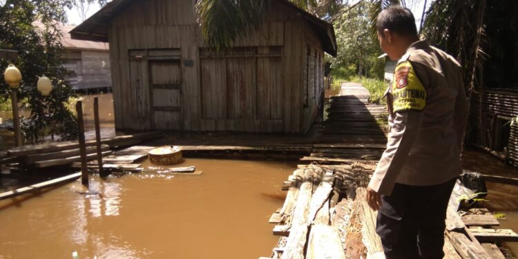 FOTO: MATAKALTENG - Personel Polsek Bukit Batu, pada saat mengecek luapan air di Kelurahan Marang.