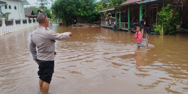 FOTO: MATAKALTENG - Personel Posek Sebangau, pada saat mengedukasi warga bahaya banjir.
