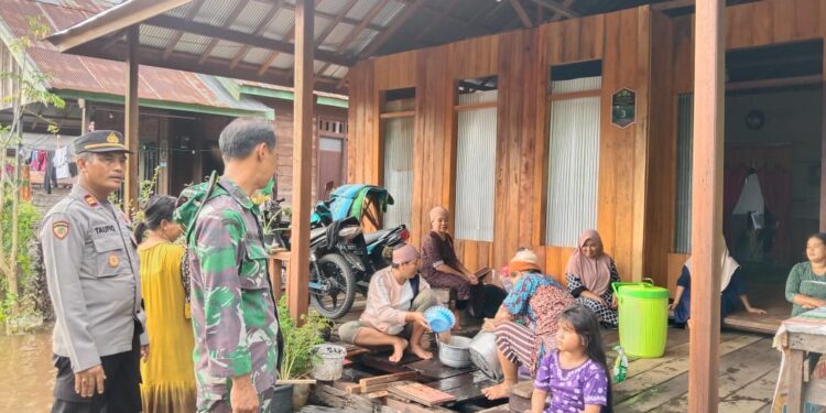 FOTO: MATAKALTENG - Kapolsek Sabangau, Iptu Ahmad Taufiq, pada saat meninjau kondisi korban banjir di Bereng Bengkel.
