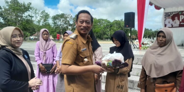 FOTO : MATAKALTENG - Bupati Sukamara, Masduki menyerahkan paket sembako pasar murah secara simbolis kepada PKM di alun-alun Masjid Agung Ad-Durrun Nafis, Senin, 24 Maret 2025.