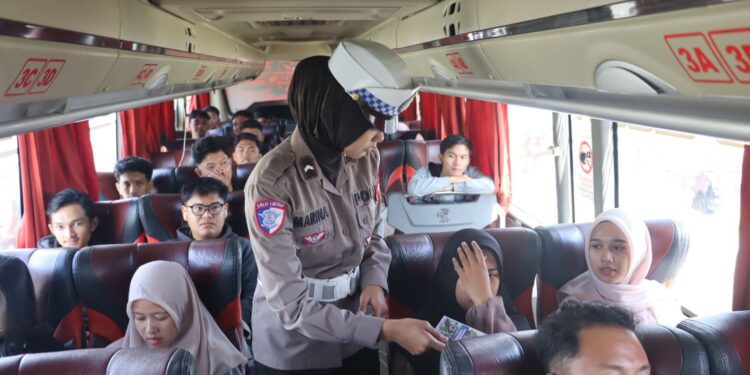 FOTO: MATAKALTENG - Personel Ditlantas Polda Kalteng, pada saat membagikan buku saku kepada pemudik.