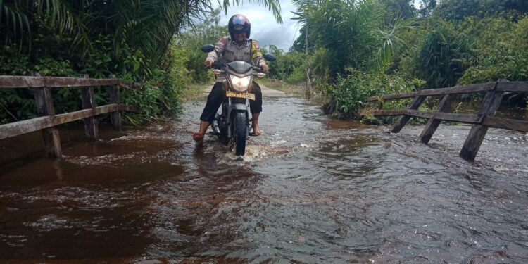 FOTO: MATAKALTENG - Personel Polsek Bukit Batu, pada saat meninjau ketinggian banjir di Kelurahan Marang.