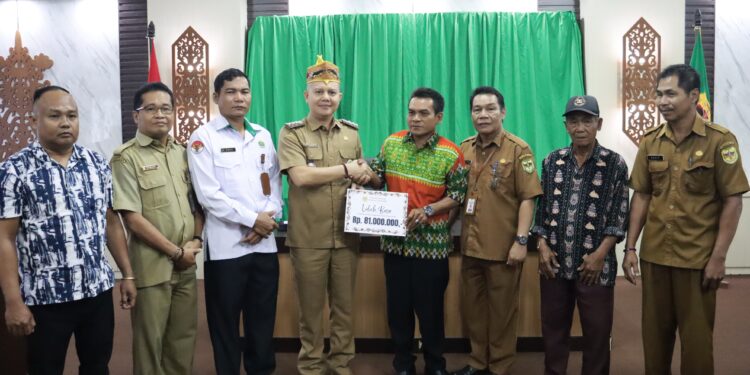 FOTO : DISKOMINFO SANTIK/MATA KALTENG - Bupati Gumas Jaya Samaya Monong didampingi Kepala Disbudpar Hansli Gonak, ketika menyerahkan bantuan kepada panitia ritual tiwah massal Desa Jangkit, Kecamatan Rungan Hulu, di ruang rapat lantai 1 kantor bupati setempat, Senin, 14 April 2025.