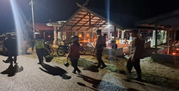 FOTO : HUMAS POLRES GUMAS/MATA KALTENG - Personel Polres Gumas melakukan pengamanan malam paskah, di TPU Kristen Jalan Temanggung Panji, Kota Kuala Kurun, Sabtu, 19 April 2025 malam.