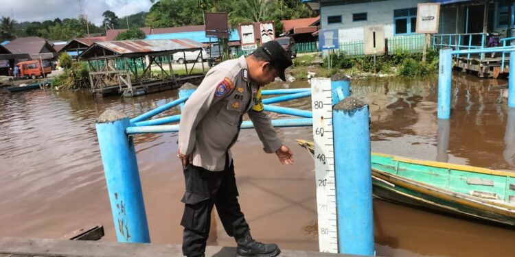 FOTO: MATAKALTENG - Personel Polsek Bukit Batu pada saat mengecek tinggi debit air DAS Rungan di Pelabuhan Pangkalima Jaya.