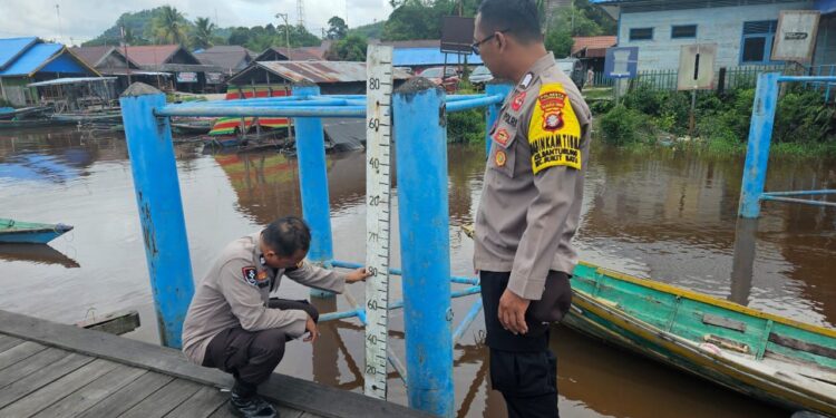 FOTO: MATAKALENG - Personel Polsek Bukit Batu pada saat melakukan pengecekan debit air di dermaga Takaras.