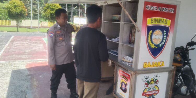 FOTO: MATAKALTENG - Personel Polsek Bukit Batu pada saat melayani warga untuk membaca buku.