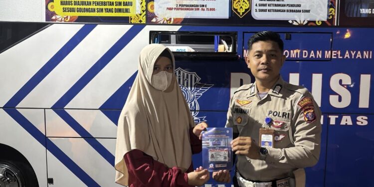 FOTO: MATAKALTENG - Personel Satlantas Polresta Palangka Raya, pada saat menyerahkan secara simbolis SIM kepada warga.
