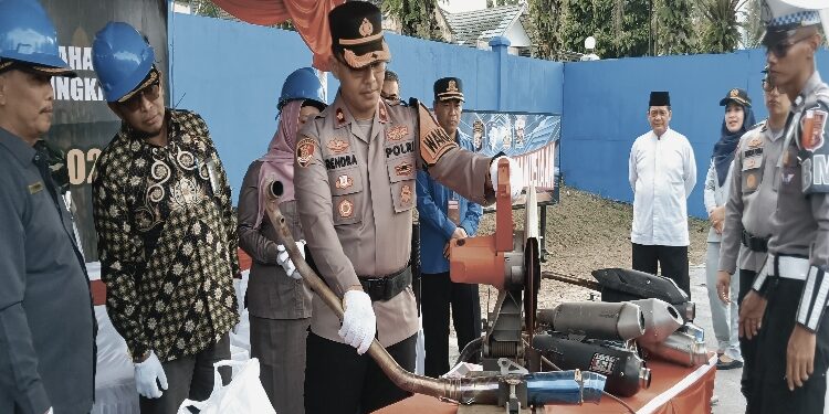 FOTO: IST/MATAKALTENG - Wakapolres Kobar Kompol Rendra Aditya Dhani melakukan pemotongan knalpot brong dengan gergaji mesin di lapangan Satlantas Polres Kobar, Kamis 20 Maret 2025.