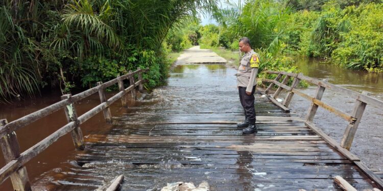 FOTO: MATAKALTENG - Bhabinkamtibmas Kelurahan Marang, Aipda Priyo Waluyo, pada saat mengecek banjir.