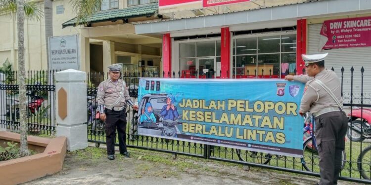 FOTO: MATAKALTENG - Personel Satlantas Polresta Palangka Raya, pada saat memasang spanduk imbauan tertib berlalu lintas.