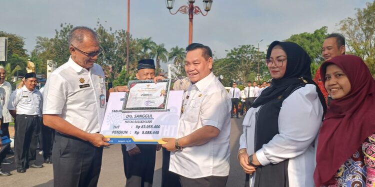 Foto: IST/MATA KALTENG - Bupati Kotawaringin Timur Halikinnor menyerahkan SK pensiun Pj Sekda Sanggul Lumban Gaol, Rabu, 30 April 2025.