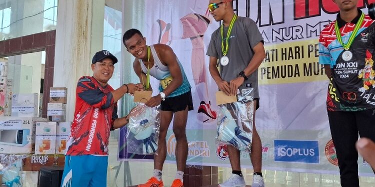 FOTO: DIAN/MATA KALTENG - Kepala Disdik Kotim M Irfansyah saat serahkan hadiah fun run dalam rangka Hardiknas di Gedung Expo Sampit, Minggu 4 Mei 2025.