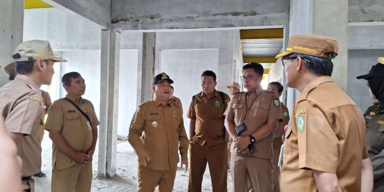 Foto: DIAN/MATA KALTENG - Plt Kadiskop UKM Kotim Johny Tangkere saat dampingi Bupati Kotim Halikinnor tinjau Pasar Mangkikit yang mangkrak, Senin 5 Mei 2025.