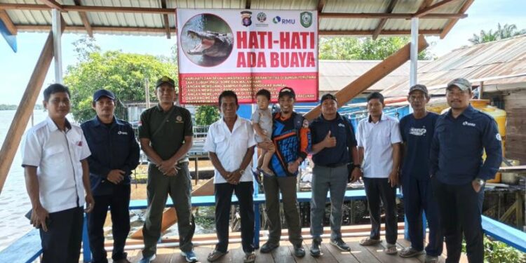 Foto: IST/MATA KALTENG - Pemasangan spanduk peringatan bahaya buaya oleh BKSDA Resort Sampit.