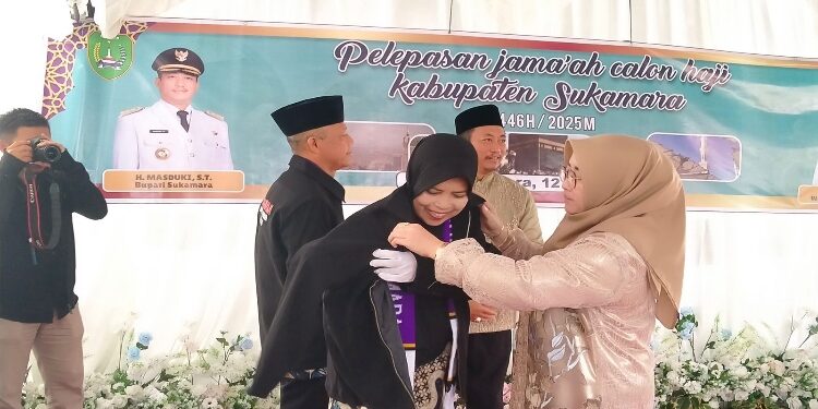 FOTO: IST/MATAKALTENG - Bupati Sukamara, Masduki dan istri memasangkan jaket kepada perwakilan Jamaah Calon Haji pada acara pelepasan.