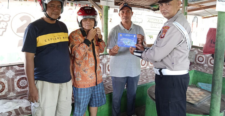 FOTO: MATAKALTENG - Personel Satlantas Polresta Palangka Raya pada saat memberikan helm gratis kepada warga.