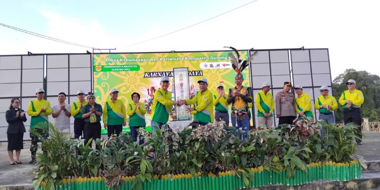 FOTO : SID/MATA KALTENG - Bupati Gumas Jaya Samaya Monong bersama Wakil Bupati Efrensia LP Umbing, unsur forkopimda, dan Sekda Richard, menyerahkan piala juara umum kepada Kepala Disbudpar Hansli Gonak, untuk diperebutkan oleh kontingen FBMM tahun 2025, di Taman Kota Kuala Kurun, Selasa, 17 Juni 2025 sore.