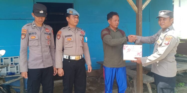 FOTO : HUMAS POLRES GUMAS/MATA KALTENG - Personel Polsek Manuhing menyerahkan bantuan kepada warga di Kelurahan Tumbang Talaken, Kecamatan Manuhing, Selasa, 17 Juni 2025.