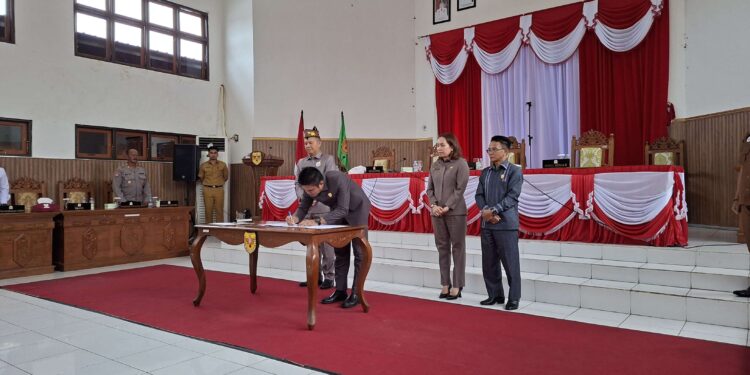 FOTO : DPRD GUMAS/MATA KALTENG - Ketua DPRD Kabupaten Gumas Binartha bersama Wakil Ketua I DPRD Nomi Aprilia dan Wakil Ketua II Espriadi, menandatangani persetujuan bersama tiga buah raperda jadi perda, di rapat paripurna ke-7 masa persidangan III tahun sidang 2025, Senin, 30 Juni 2025.