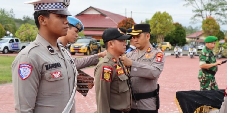 FOTO : HUMAS POLRES GUMAS/MATA KALTENG - Kapolres Gumas AKBP Heru Eko Wibowo menyematkan pita kepada perwakilan apel gelar pasukan operasi patuh telabang 2025, di halaman polres setempat, Senin, 14 Juli 2025.