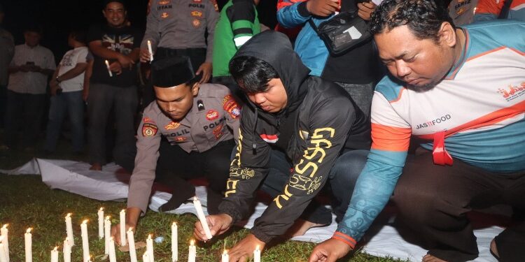 FOTO: IST/MATAKALTENG- Komunitas Ojol di Sampit bersama aparat kepolisian saat menggelar doa bersama untuk almarhum Affan Kurniawan, Minggu 31 Agustus 2025 malam.