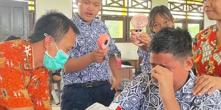FOTO : MATA KALTENG - Pegawai Puskesmas Tampang Tumbang Anjir saat melakukan pemeriksaan kesehatan gratis dengan menyuntik salah satu peserta didik SMPN 4 Kurun, pekan lalu.