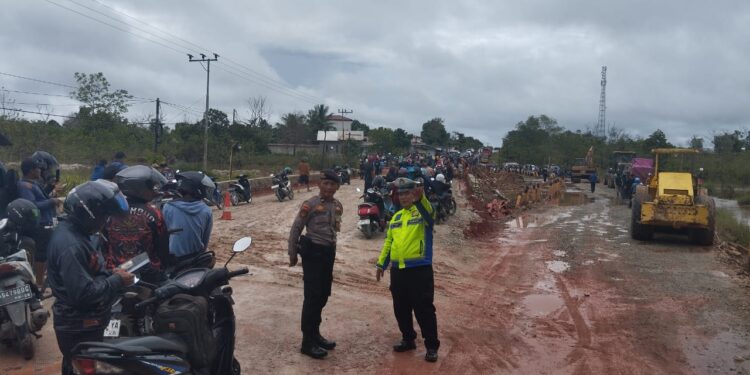 FOTO: MATAKALTENG - Personel Satlantas Polres Katingan, pada saat melakukan pengaturan lalu lintas di jalan yang putus.