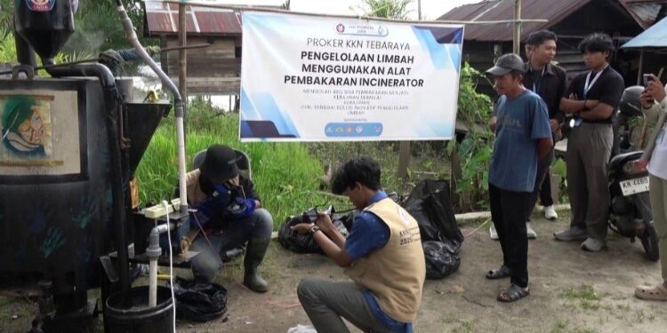Foto:IST/MATA KALTENG - Praktek penggunaan alat pelebur sampah di Desa Telaga Baru bersama mahasiswa KKN.