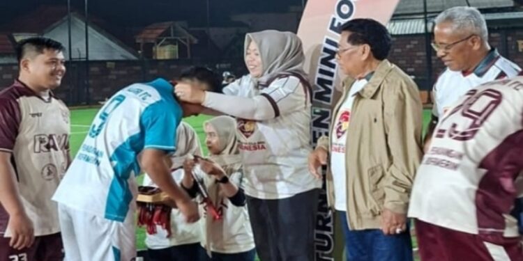 FOTO: IST/MATAKALTENG - Bupati Kotawaringin Barat Hj Nurhidayah mengalungkan medali pemenang turnamen mini footbal Cup KSMI 2025, Sabtu 8 November 2025.