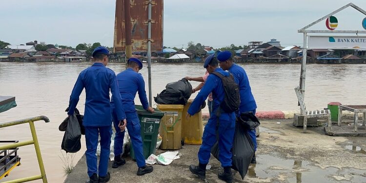 FOTO: IST/MATAKALTENG- Personel Ditpolairud Polda Kalteng bersama warga Kampung Tengah membersihkan sampah di pesisir DAS Kahayan, Palangka Raya. 