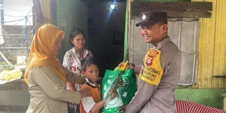 FOTO: Bhabinkamtibmas Kelurahan Panarung, Aiptu Edy Prayitno bersama Kasi Kesos Kelurahan Panarung, Sri Lestari saat menyerahkan paket sembako untuk anak berkebutuhan khusus di wilayah Panarung, Selasa (10/3/2026).
