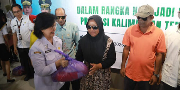 FOTO: IST - Pj. Sekretaris Daerah Provinsi Kalimantan Tengah Linae Victoria Aden saat melakukan penyerahan bantuan paket sembako kepada para penerima manfaat operasi katarak gratis.