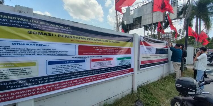 FOTO: Tim Kuasa Hukum R. Atu Narang, pada saat memasang spanduk somasi, di pagar eks kantor DPD PDIP Kalteng.