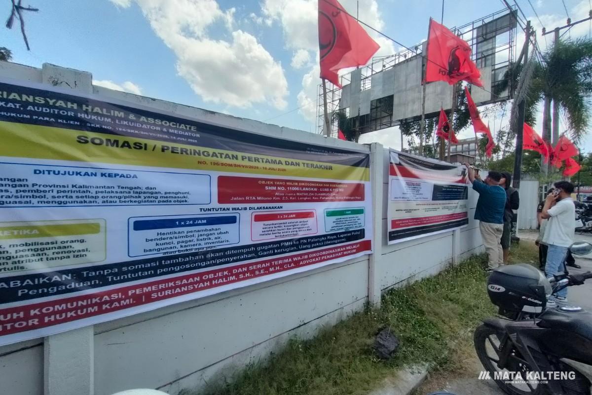 FOTO: Tim Kuasa Hukum R. Atu Narang, pada saat memasang spanduk somasi, di pagar eks kantor DPD PDIP Kalteng.
